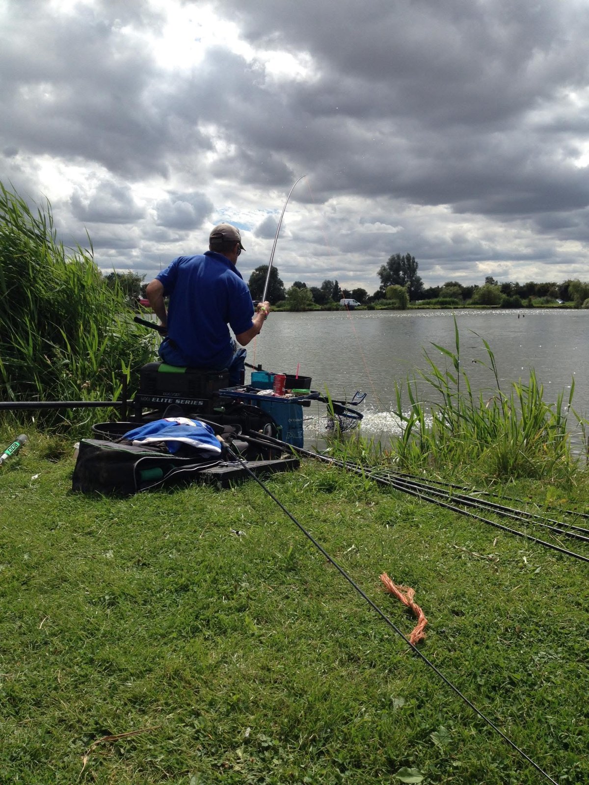 Dale Shepherd fishing with a long pole beside a lake.