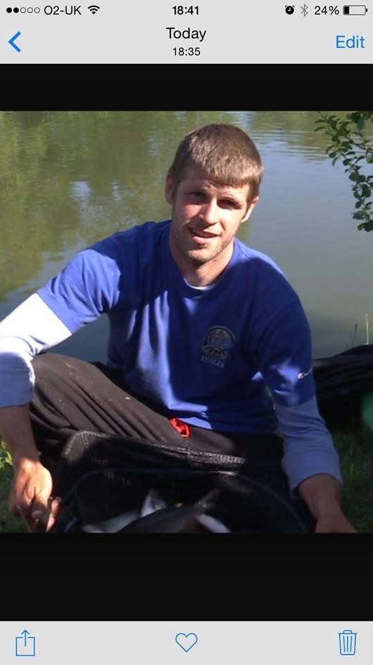 An earlier photograph of Dale Shepherd sitting beside the water.