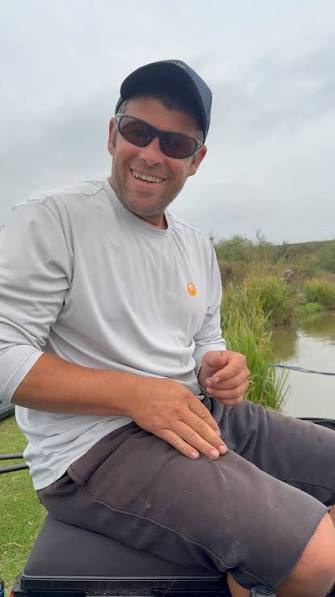 Dale Shepherd smiling while sitting beside the water.