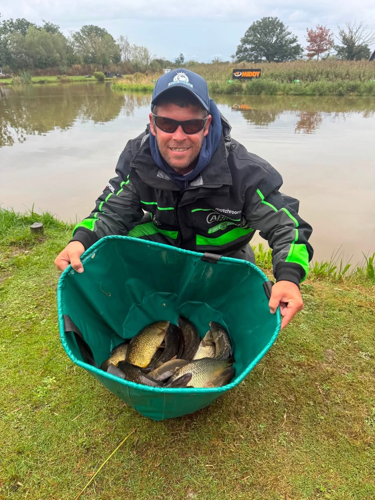 Dale Shepherd with a basket of fish at the waterside.